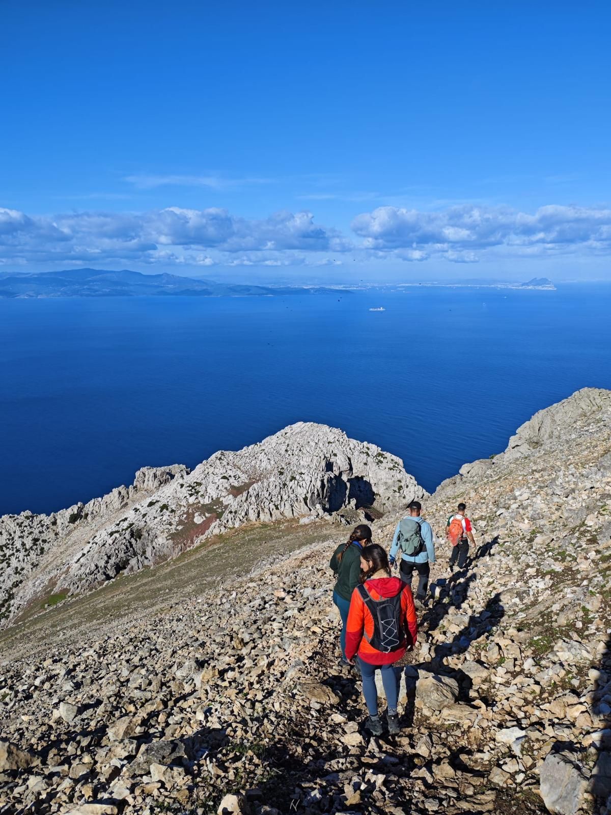 Hikers descending Jebel Musa with the Strait of Gibraltar beyond
